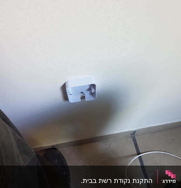 בסיס שקע חשמלי מותקן על קיר לבן